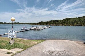 Un quai où sont amarrés des bateaux, un panneau indiquant qu’il est réservé à l’accès par rampe et à l’usage temporaire, et un ciel dégagé.