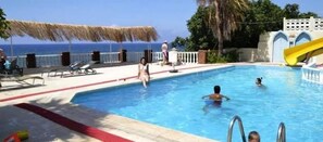 Una piscina al aire libre de temporada, sombrillas