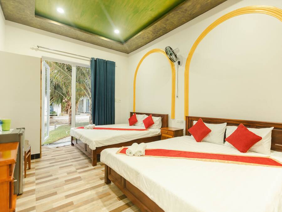 Habitación de hotel con dos camas, un escritorio y vistas al exterior.