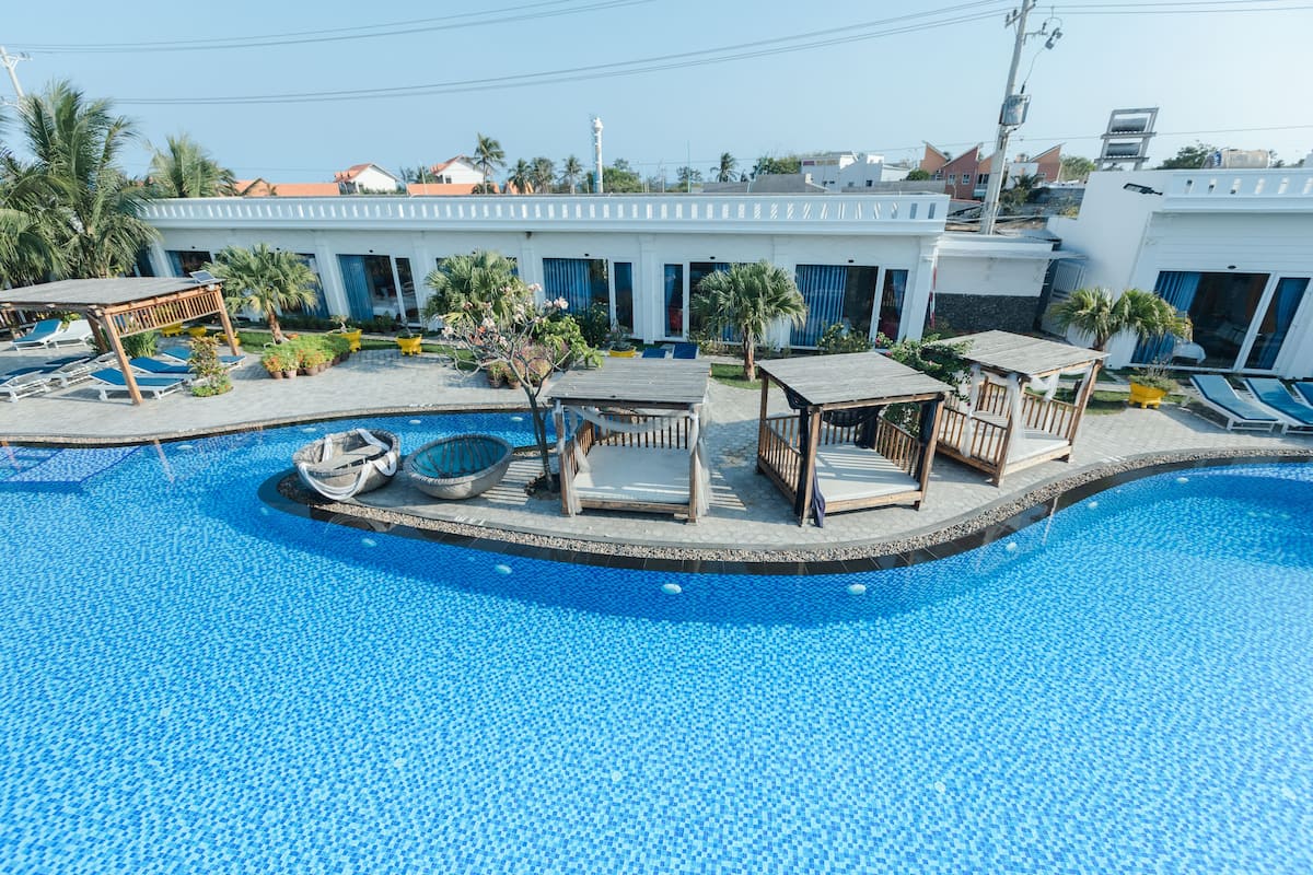 Una piscina con lettini e un’area prendisole in legno.
