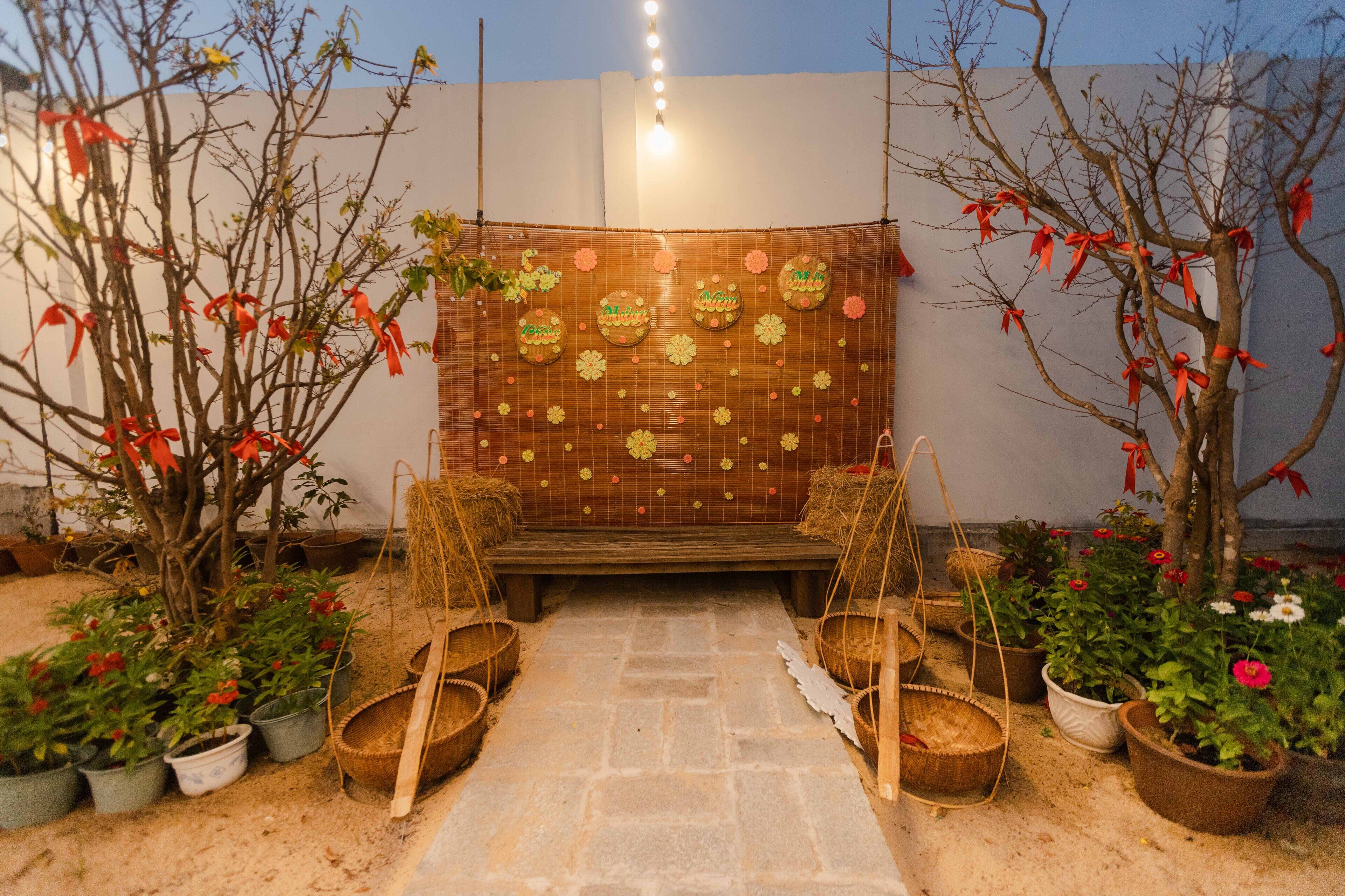 A garden with a stone pathway, potted plants, and a wooden bench.