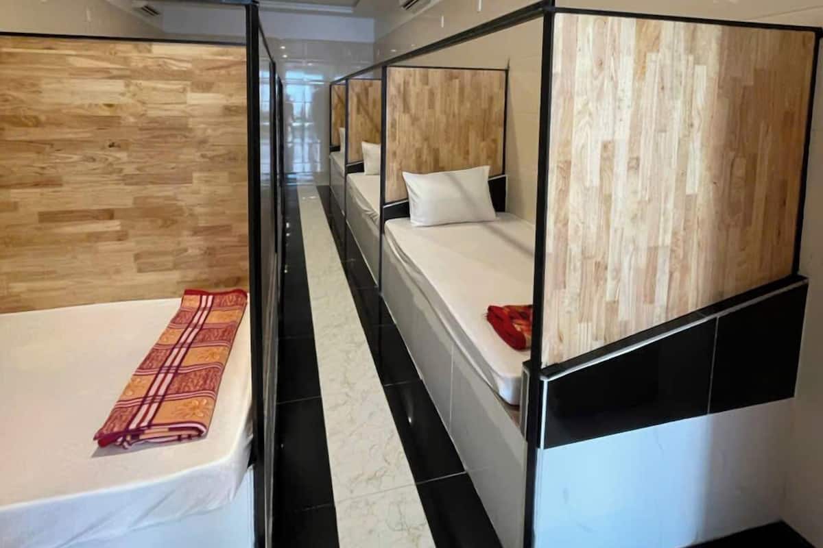 Camera d'albergo moderna con letti a castello, una parete decorativa in legno e pavimento in marmo.