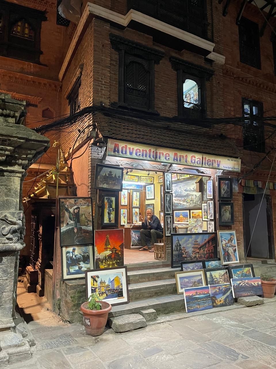 Une galerie d’art où une variété de tableaux sont exposés à l’extérieur.
