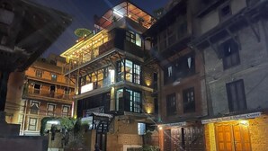 Un edificio tradicional con varios pisos, balcones y una entrada a nivel de calle.