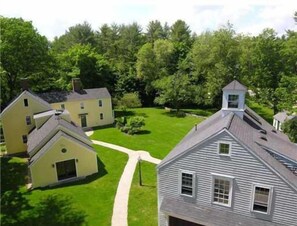 A residential area with multiple houses, a well-maintained lawn, and a clear sky. - Charming and Romantic Arundel Farm.  Close to all Beaches in the Kennebunks! (Kennebunkport)
