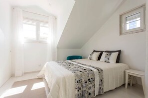 Une chambre à coucher avec un lit, une fenêtre et une petite table.