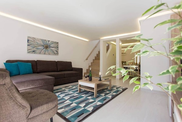 Un salon moderne avec un canapé, une table basse et un tapis à motifs.