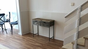 A room with a wooden floor, a table with drawers, a chair, and a staircase. - Vilasardemarlux 1 NEAR BARCELONA 1 (Vilassar de Mar)
