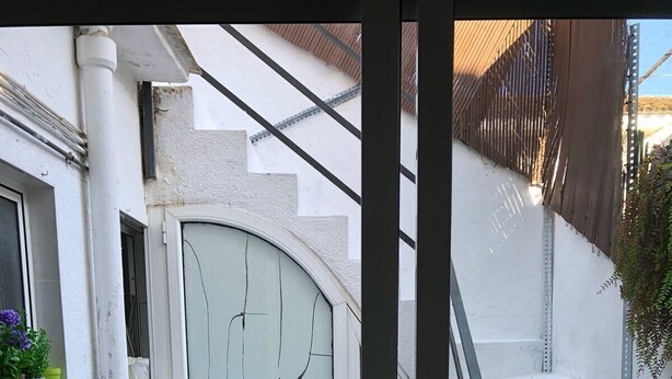 A small outdoor patio with a wooden table and chairs, a white door, and a set of white stairs. - Vilasardemarlux 1 NEAR BARCELONA 1 (Vilassar de Mar)