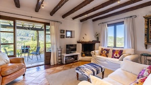 A spacious living room with a fireplace, large windows, and a cozy seating area. - Luxury secluded Villa with Infinity Pool &Panoramic view 20 minutes from beaches (Campanet)