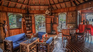 Ein gemütlicher, rustikaler Raum mit Holzboden, einem blauen Sofa, einem Holztisch und einem Bücherregal.
