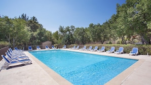 A rectangular swimming pool with a tiled edge, surrounded by a low stone wall. - Maisonette in Gordes with Provençal Charm (GORDES)