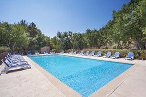 A rectangular swimming pool with a tiled edge, surrounded by a low stone wall. - Maisonette in Gordes with Provençal Charm (GORDES)