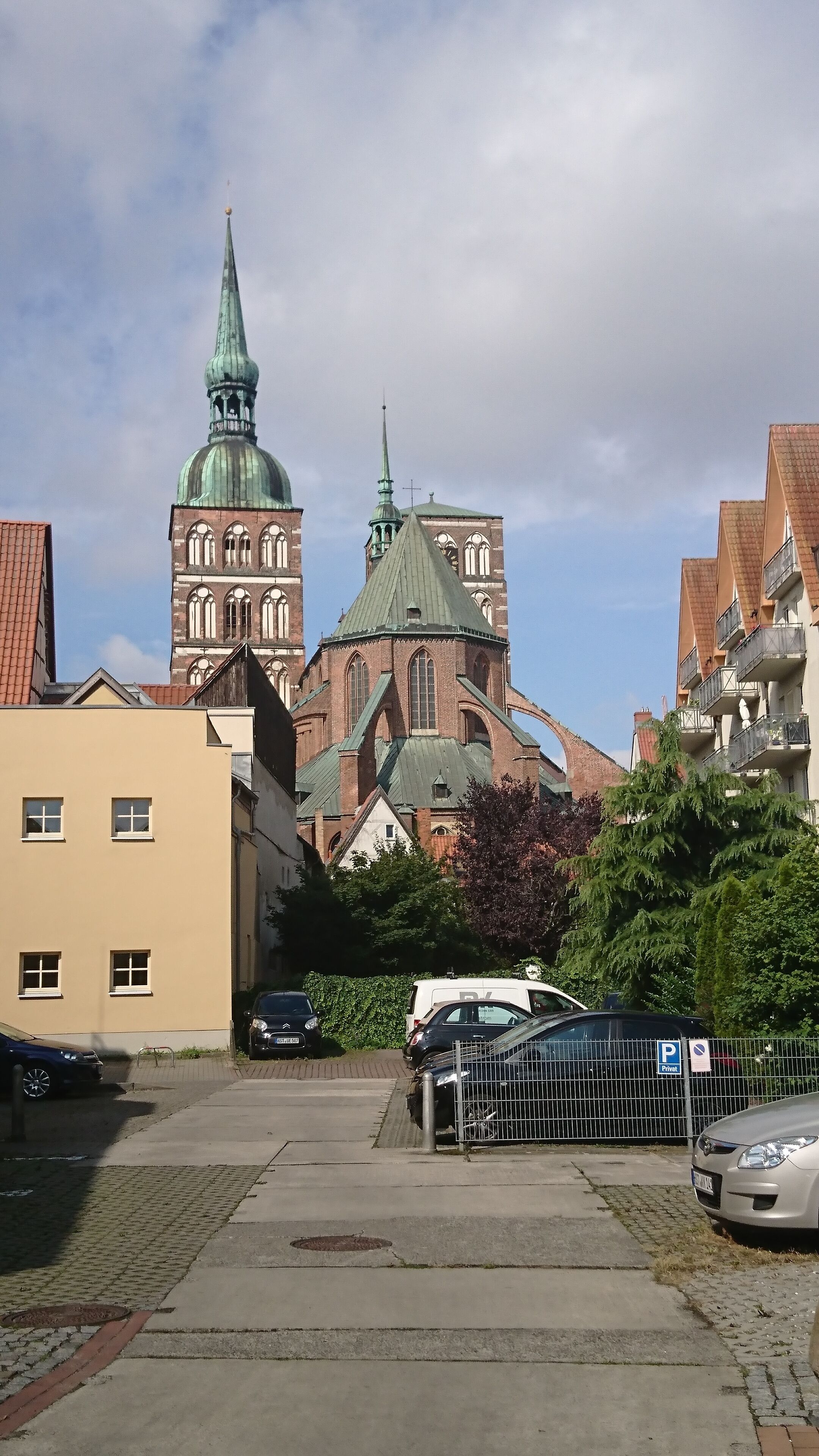 A historic church with a prominent green spire and a brick facade.
