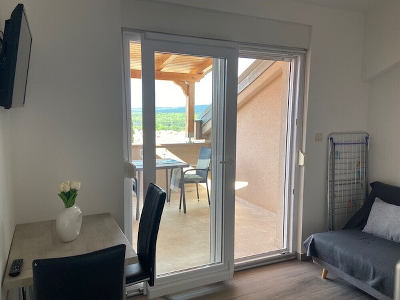 A room with a sliding glass door leading to an outdoor area with a table and chairs.