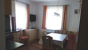 A compact living space with a kitchenette, dining area, and a sofa.