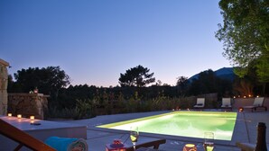 A poolside setting with a table, chairs, and a bottle of wine. - Villa Violetta, 4/5 pers, 2 bedrooms, shared pool in the heart of the Corsican maquis (porto vecchio)