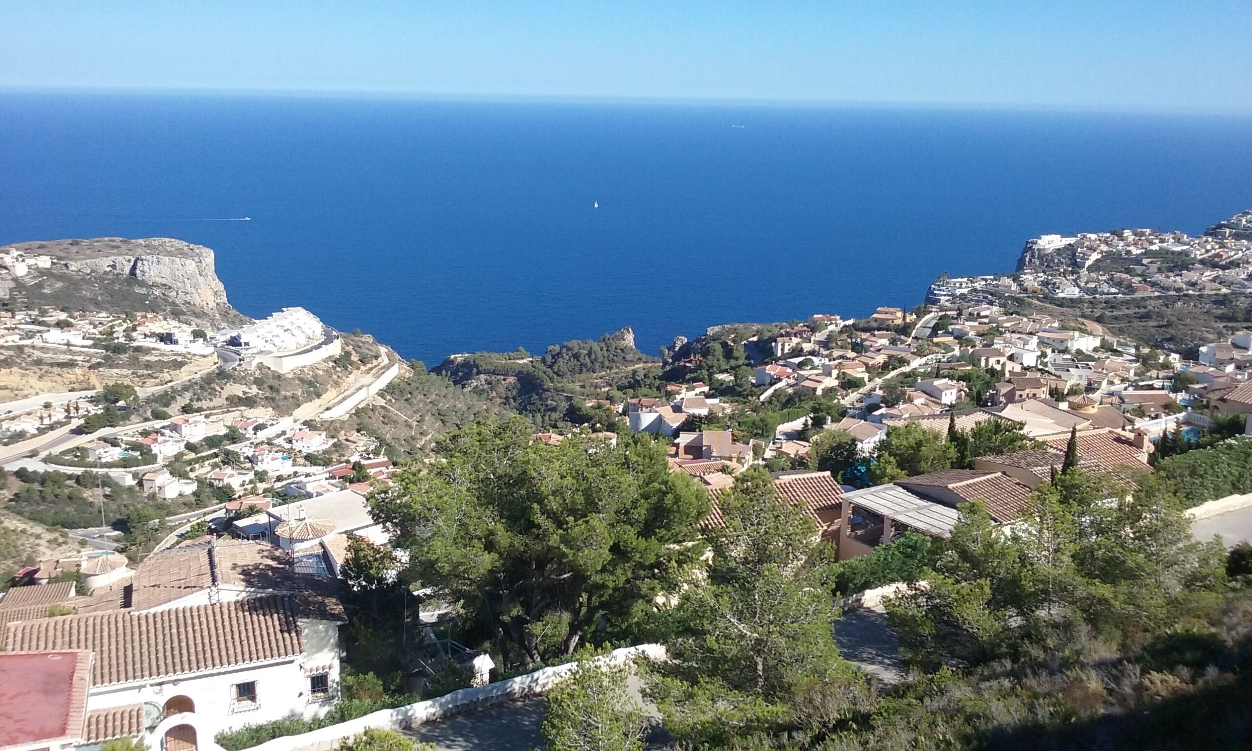 Eine Küstenstadt mit einer markanten Klippe, terrassenförmig angelegten Häusern und Blick auf das Meer.