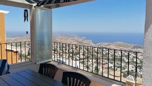 Un balcon avec vue sur la mer et sur la ville.