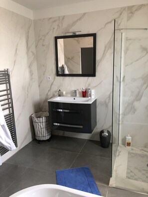 Tina con regadera, secadora de cabello, toallas, papel de baño 