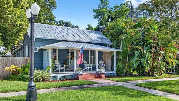 A house with a porch, a flag, and a well-maintained lawn. - 2BR COTTAGE IN SANFORD HISTORIC DISTRICT (Sanford)