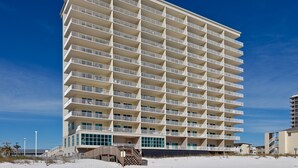 A multi-story hotel with a uniform exterior, balconies on each floor, and a beachside location. - Gulf Front! Wrap around Balcony Corner Unit, Perfect Gulf Views! CLEAN!   (Gulf Shores)