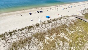 A beach with clear skies, a sandy shore, and a few umbrellas. - Gulf Front! Wrap around Balcony Corner Unit, Perfect Gulf Views! CLEAN!   (Gulf Shores)