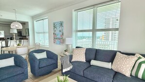 A modern living room with a sofa, chairs, a coffee table, and a painting. - Gulf Front! Wrap around Balcony Corner Unit, Perfect Gulf Views! CLEAN!   (Gulf Shores)