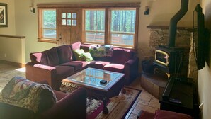 Una sala de estar acogedora con chimenea, ventanas amplias y un espacio de descanso cómodo.