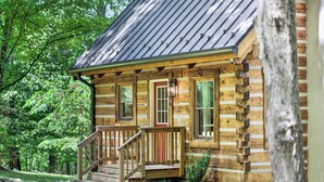 A log cabin with a porch, wooden steps, and a metal roof. - Falling Leaf Cabin Rustic Charm With Modern Decor! High Speed Internet!  (Rileyville)