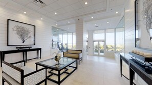 Enjoy a serene view from the large window, relax on the sofa, and unwind with a cup of coffee at the glass table.