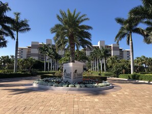 Stroll through beautifully landscaped gardens surrounding a modern building with balconies.