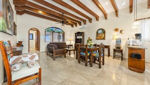 Amplia sala de estar con vigas de madera, un comedor y una cocina.