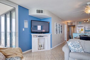 Relax in this stylish living room with a large flat-screen TV, comfortable sofa, and dining area.