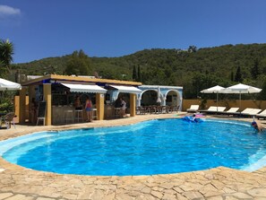 Utomhuspool, parasoller och solstolar