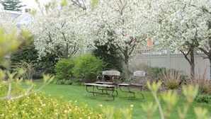 A garden with picnic tables and blooming trees. - The Springwater B&B (Saratoga Springs)