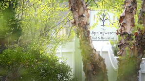 A sign for 'Springwater Bed & Breakfast' amidst greenery. - The Springwater B&B (Saratoga Springs)