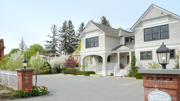 A two-story building with a porch and a sign indicating it is a bed and breakfast with parking. - The Springwater B&B (Saratoga Springs)