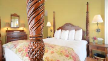 A bed with a floral bedspread, a wooden headboard, and a nightstand with a lamp.