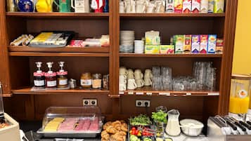 A breakfast buffet with various food items, condiments, and beverages.