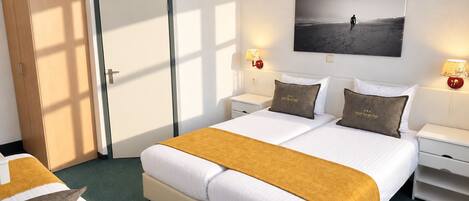 A hotel room with a large bed, two bedside tables, a wardrobe, and a wall-mounted picture.