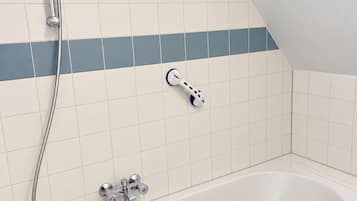 Een badkamer met een bad, een handdouche en een massageapparaat.