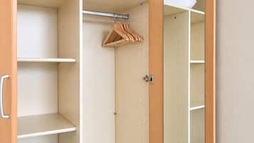 Un vestidor con estantes, barra para colgar ropa y un espejo.