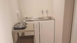 A small kitchen with a sink, two cabinets, and a built-in shelf. - 8 Soenie Avenue Self Catering (Akasia)