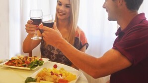 A dining table with plates of food and glasses of red wine. - Hotel Solmar (San Clemente)