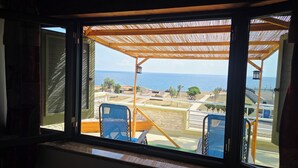 Un balcón con vistas al mar, una pérgola y mobiliario de exterior.