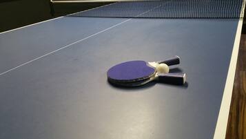 A table tennis table with a net and paddles.