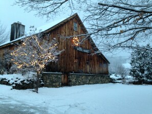 Une cabane en bois, avec des fondations en pierre, une cheminée et une enseigne sur laquelle on peut lire : « The Shovel Handle ».