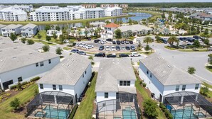 A residential area with multiple two-story houses, a central parking lot, and a swimming pool area. - Single Family Home @ Storey Lake Resort Vacation Homes in Kissimmee...!!! (Kissimmee)