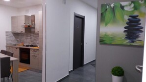 Una cocina moderna con comedor, una puerta y un cuadro de piedras y agua en la pared.
